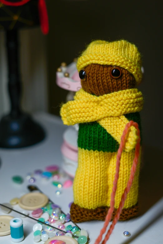 a close up of a stuffed animal on a table, inspired by Kate Greenaway, hurufiyya, yellow and green scheme, dark-skinned, ski mask, amber