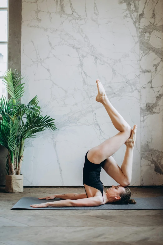 a man doing a yoga pose on a yoga mat, a picture, by Carey Morris, trending on pexels, arabesque, brunette fairy woman stretching, on a large marble wall, high forehead, botanicals