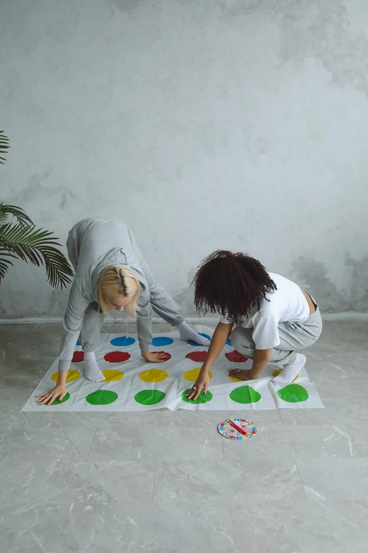 a couple of kids playing a game on a rug, by artist, pexels contest winner, interactive art, twister, on grey background, white, college