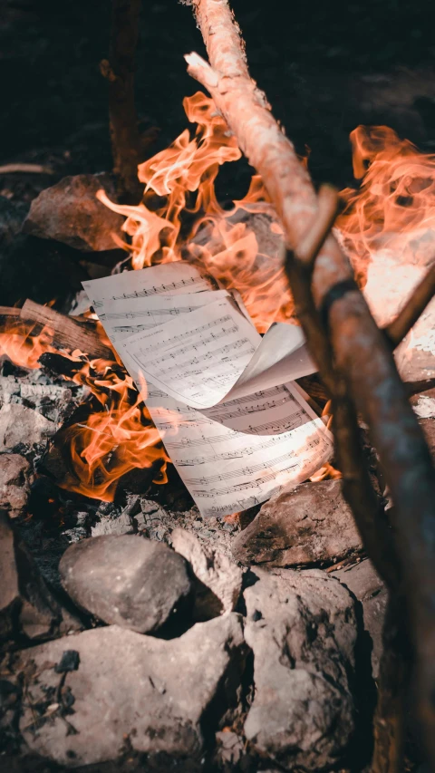 a piece of paper sitting on top of a fire, an album cover, pexels contest winner, manuscript, environmental shot, bard, high quality photo