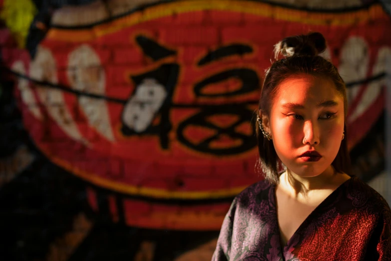 a woman in a kimono standing in front of a wall, a portrait, inspired by Wu Zhen, unsplash, graffiti, avatar image, dim lit, south east asian with round face, looking serious