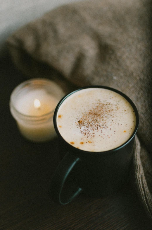 a cup of coffee and a candle on a table, promo image, light tan, cinnamon, multiple stories