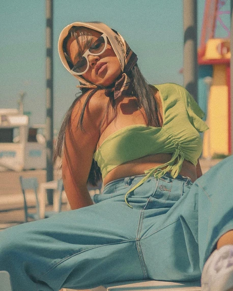 a woman sitting on top of a white chair, an album cover, by Olivia Peguero, trending on pexels, happening, wearing sunglasses and a cap, ((greenish blue tones)), wearing yellow croptop, tanned ameera al taweel