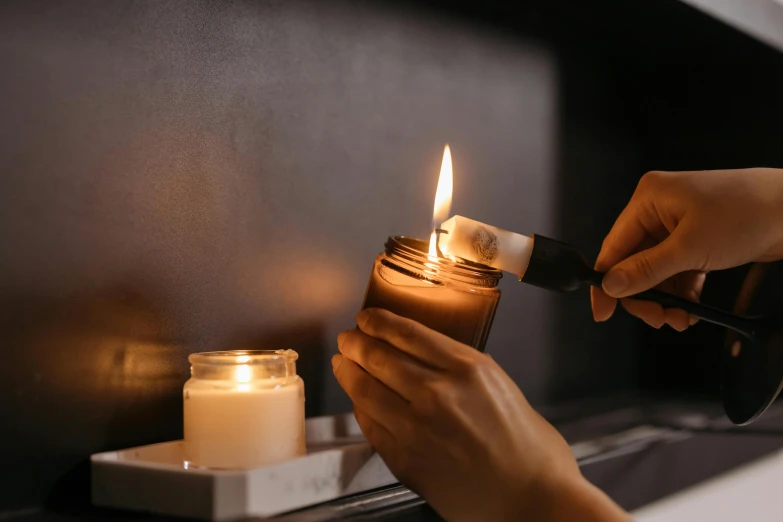 a close up of a person lighting a candle, trending on pexels, sustainable materials, torches on wall, cosy fireplace, toothpaste refinery