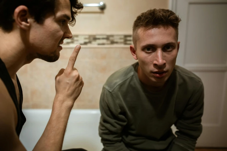 a couple of men sitting on top of a bathroom floor, pexels contest winner, antipodeans, pleading face, thin young male, with pointing finger, casey cooke