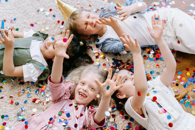 a group of children laying on top of a floor covered in confetti, pexels contest winner, incoherents, kid named finger, birthday party, avatar image, finger