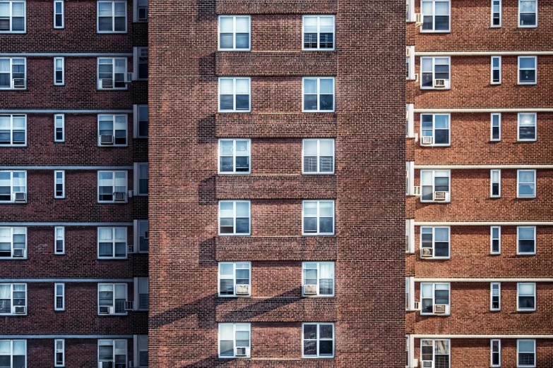 a couple of tall buildings next to each other, by Carey Morris, unsplash, photorealism, red bricks, ignant, house windows, square lines