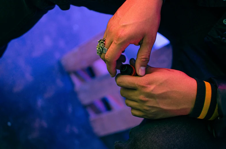 a close up of a person holding a cell phone, a tattoo, by Adam Marczyński, pexels contest winner, visual art, gunsmithing, uv blacklight, revolver on chair, mechanic