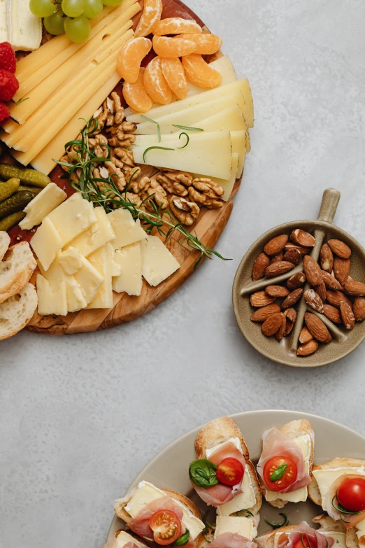 a table topped with lots of different types of food, a still life, tillamook cheese, on a gray background, 3 - piece, eating a cheese platter