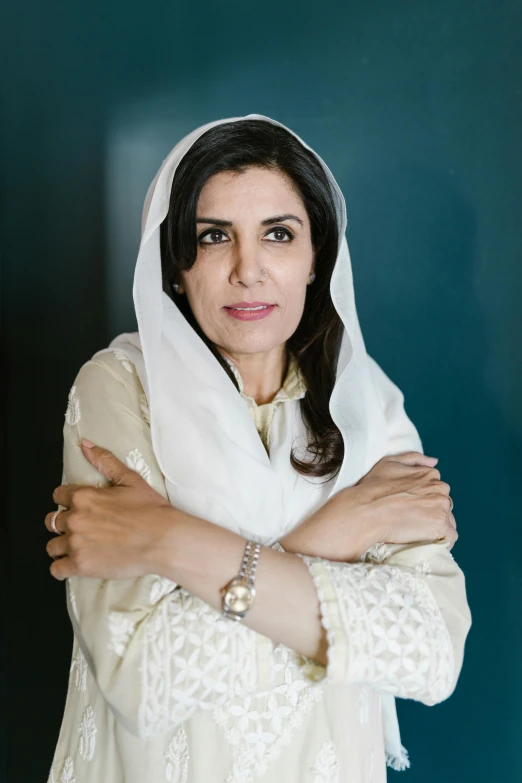 a woman in a white shawl posing for a picture, inspired by Maryam Hashemi, arms folded, mogul khan, press shot, portrait image