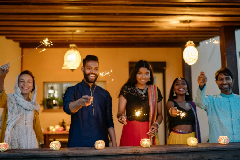 a group of people standing next to each other holding sparklers, hurufiyya, lanterns on the porch, sharandula, profile image, holiday vibe