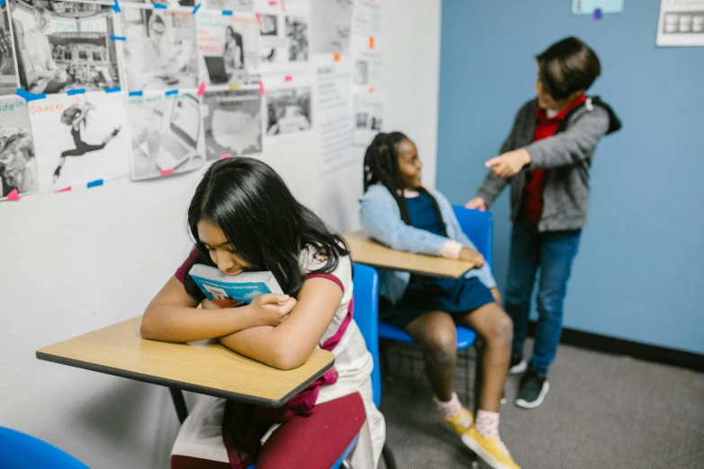 a group of children sitting at desks in a classroom, pexels contest winner, fighting with angles, vannessa ives, profile image, hunched shoulders