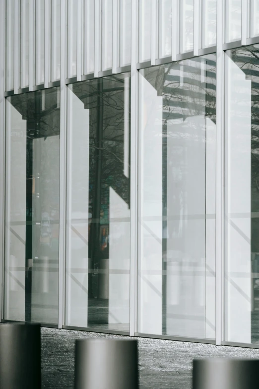 a man standing in front of a building holding an umbrella, by Nina Hamnett, unsplash, modernism, white panels, transparent corrugated glass, theater access corridor, detail structure