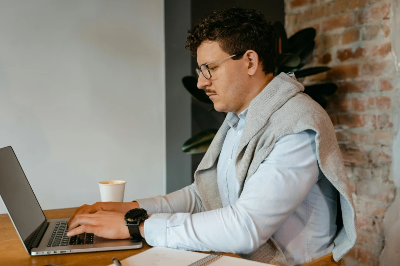 a man sitting at a desk using a laptop computer, a screenshot, by Carey Morris, trending on pexels, lachlan bailey, casually dressed, concentration, professional profile picture