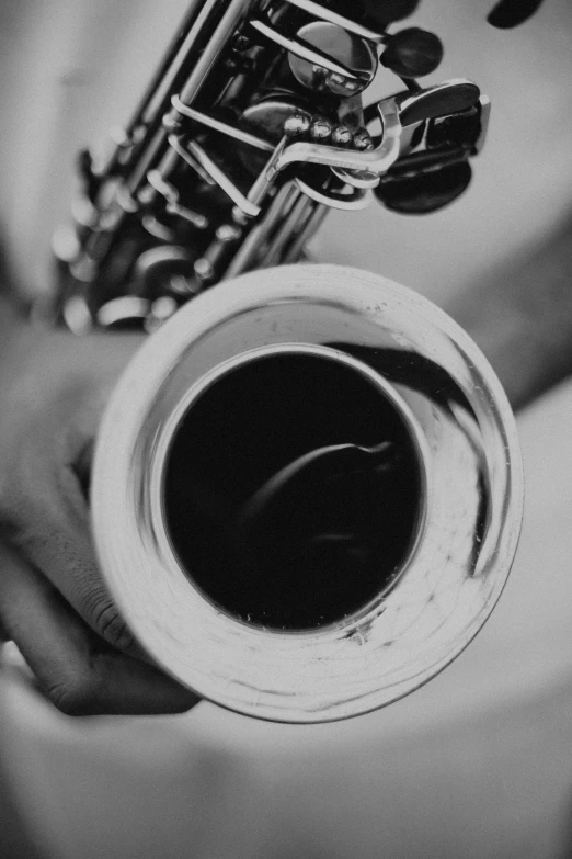 a close up of a person holding a saxophone, a black and white photo, by Felix-Kelly, 🚿🗝📝