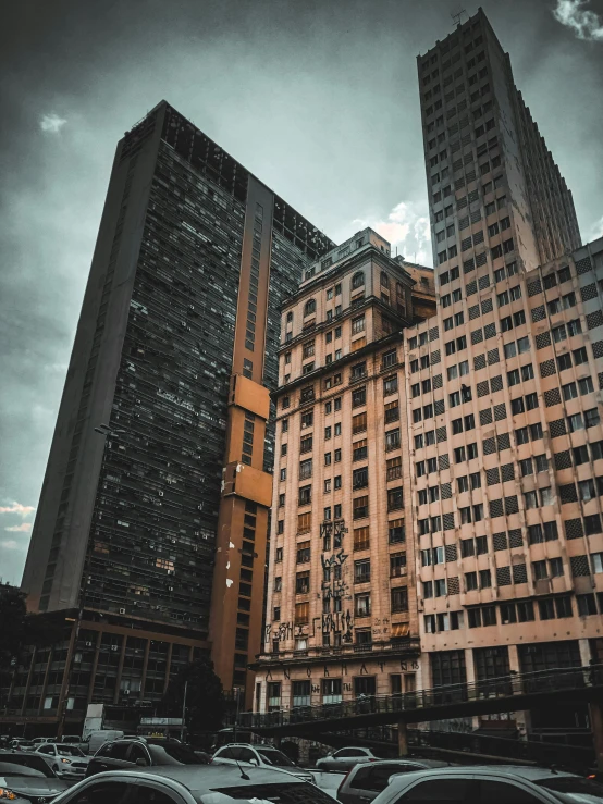 cars parked in a parking lot in front of tall buildings, a photo, pexels contest winner, brutalism, in sao paulo, haunted gothic hotel, ((oversaturated)), portrait of tall