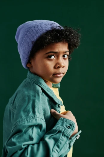 a young boy wearing a purple hat and jacket, trending on pexels, photorealism, muted green, teal studio backdrop, mixed race, beanie