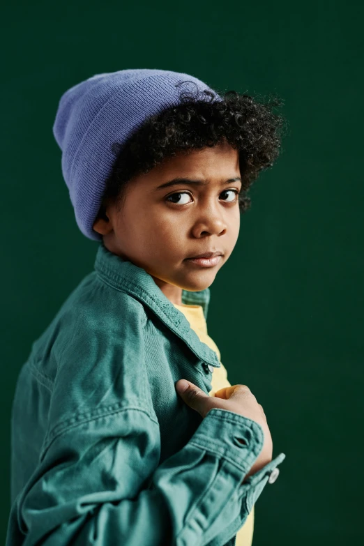 a young boy wearing a purple hat and jacket, trending on pexels, photorealism, muted green, teal studio backdrop, mixed race, beanie
