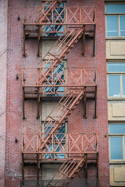 a fire escape staircase on the side of a building, inspired by Robert Bechtle, rusty pipes, 2019 trending photo, new york buildings, colour photograph