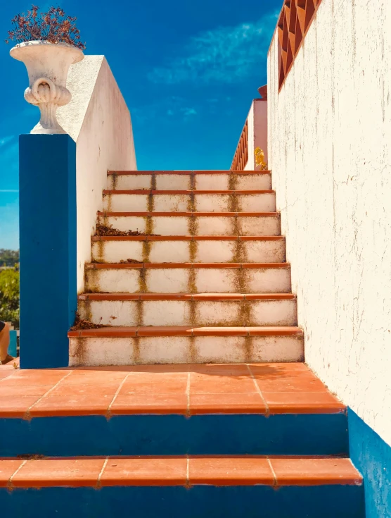 a set of stairs leading up to the top of a building, an album cover, inspired by Rodolfo Escalera, pexels contest winner, cerulean blue and burnt sienna, marbella landscape, thumbnail, tiles