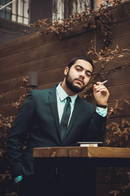 a man in a suit smoking a cigarette, an album cover, inspired by Elsa Bleda, pexels contest winner, an olive skinned, ready for a meeting, modeling shoot, hispanic