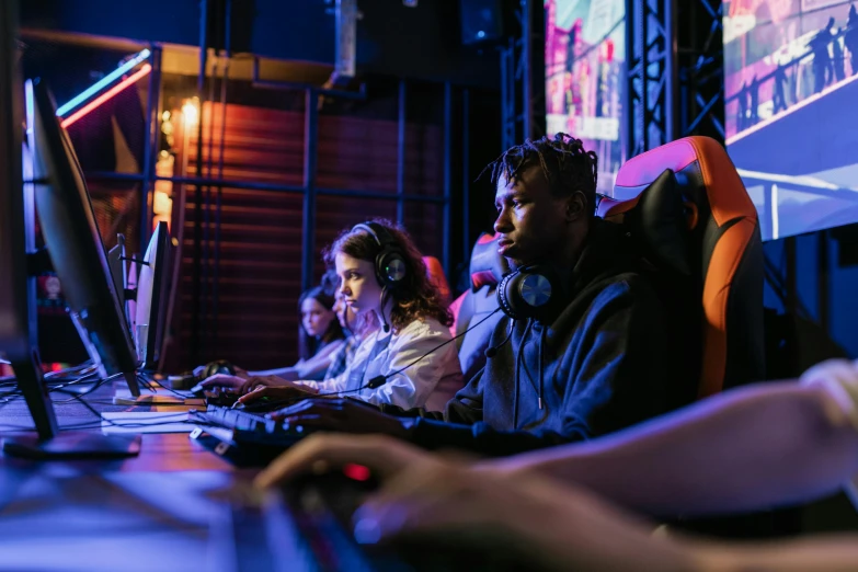 a group of people sitting in front of computers, playing video games, instagram post, high resolution, brown