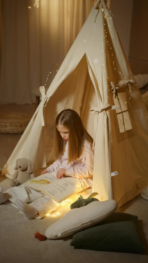 a little girl sitting in a teepee reading a book, pexels contest winner, light and space, beige, leds, linen, demur