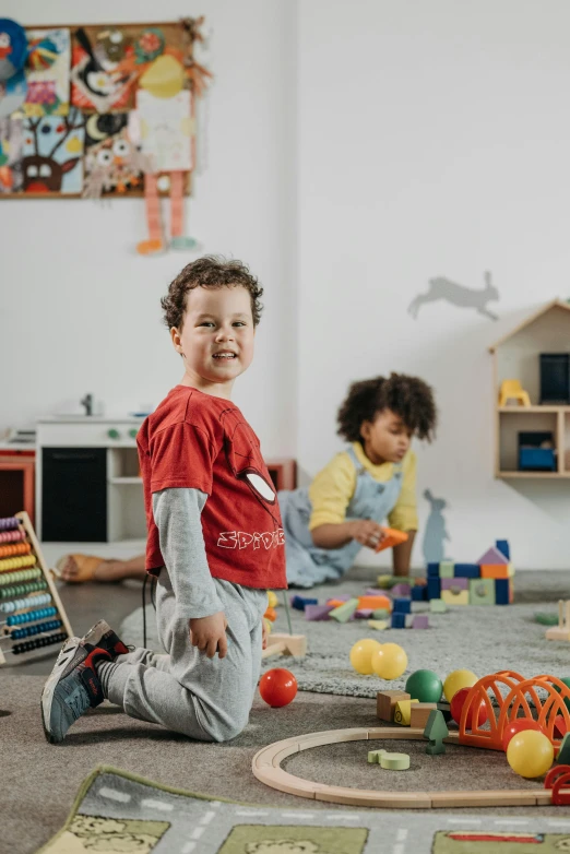 two children sitting on the floor playing with toys, pexels contest winner, standing in corner of room, photo of a classroom, high quality photo, promotional image