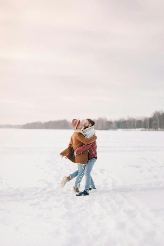 a man and woman hugging in the snow, pexels contest winner, trending on tiktok, snowy field, plain background, playful