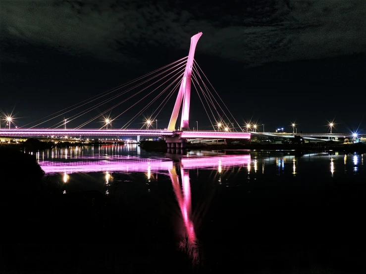 a bridge over a body of water at night, by Jacob Toorenvliet, unsplash contest winner, interactive art, soft light 4 k in pink, glasgow, flawless structure, highly reflective light