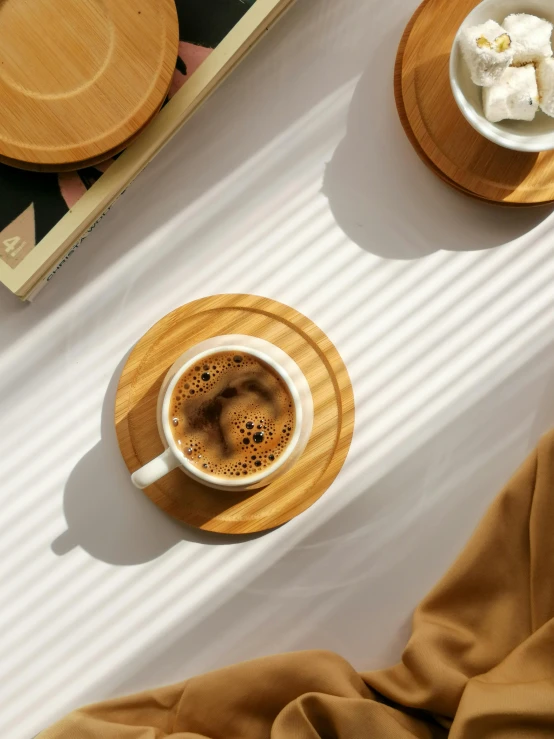 a couple of cups of coffee sitting on top of a table, inspired by Muggur, sumatraism, bamboo wood, detailed product image, flatlay, rounded lines