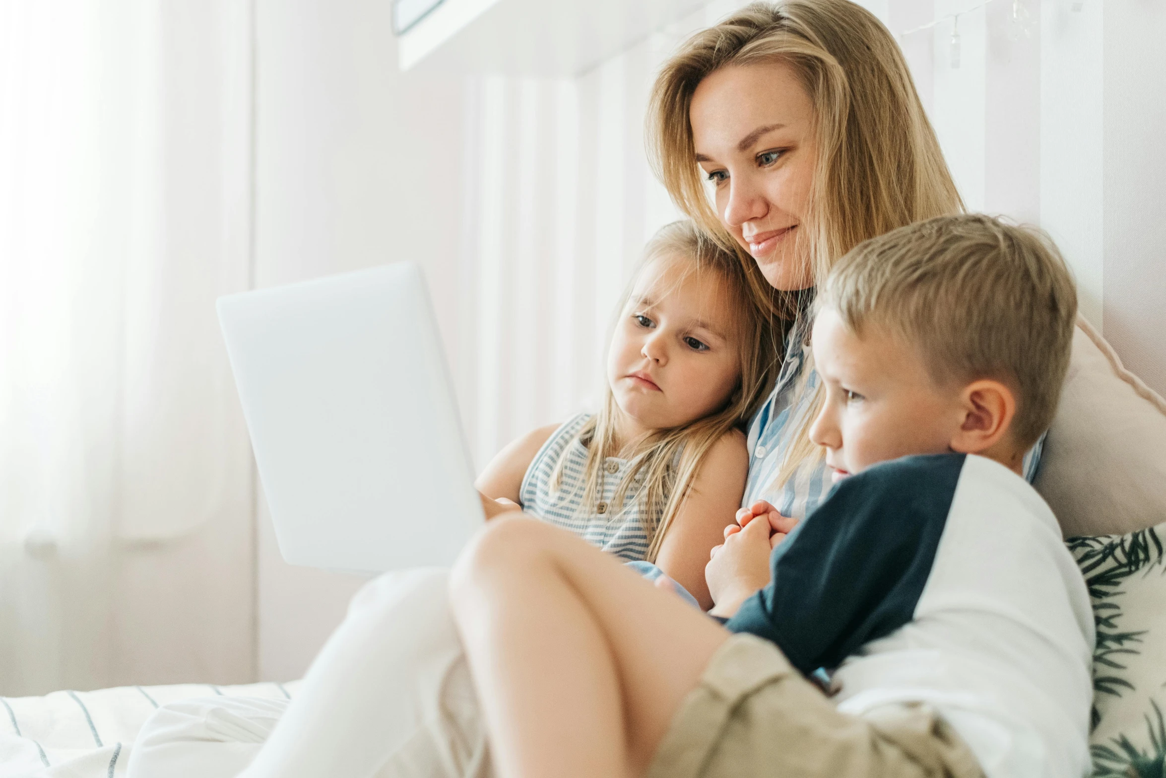 a woman and two children sitting on a bed looking at a laptop, a cartoon, pexels, instagram post, kids movie, maternal, oscar winning