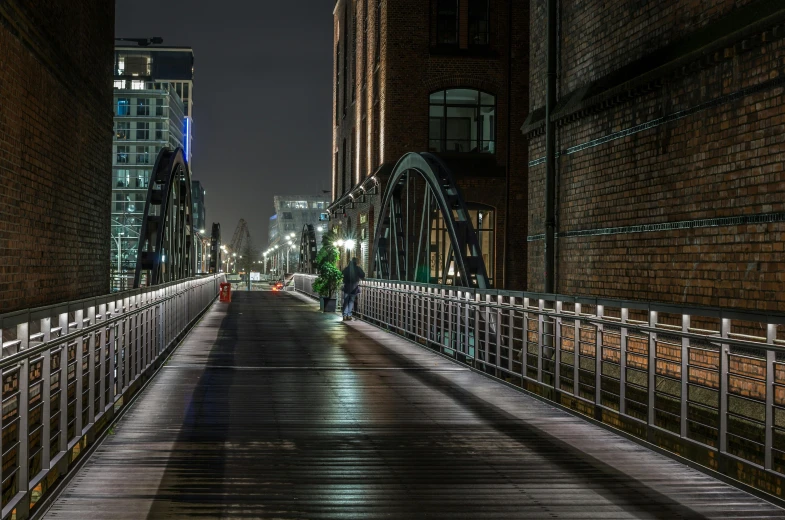a person walking across a bridge at night, inspired by Thomas Struth, unsplash contest winner, manchester, photorealistic streetscape, thumbnail, hannover