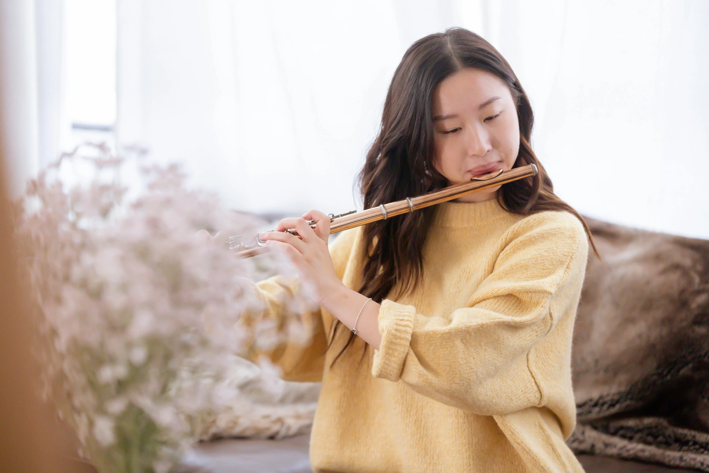 a woman sitting on a couch playing a flute, inspired by Gu Kaizhi, trending on pexels, arabesque, wearing wheat yellow gauze, romantic lead, hwang se - on, brown