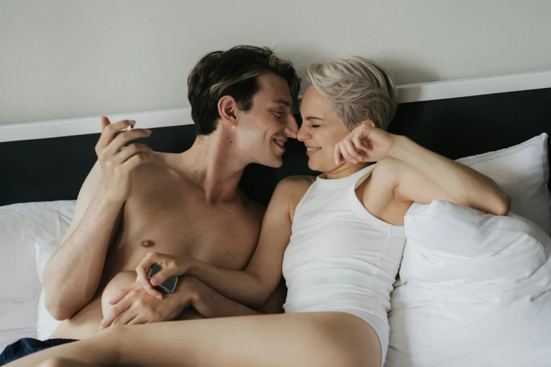 a man and woman laying in bed next to each other, trending on pexels, lesbian embrace, milk bar magazine, with pale skin, lachlan bailey