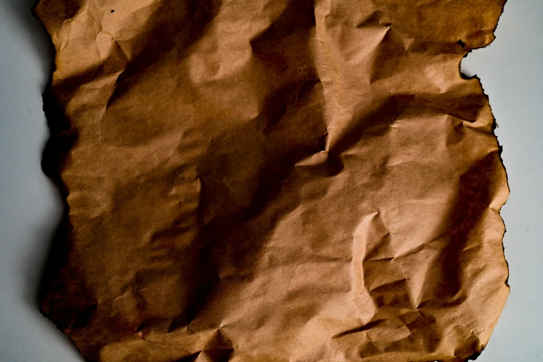 a piece of brown paper sitting on top of a table, pexels contest winner, visual art, background image, topography, recipe, wrinkled
