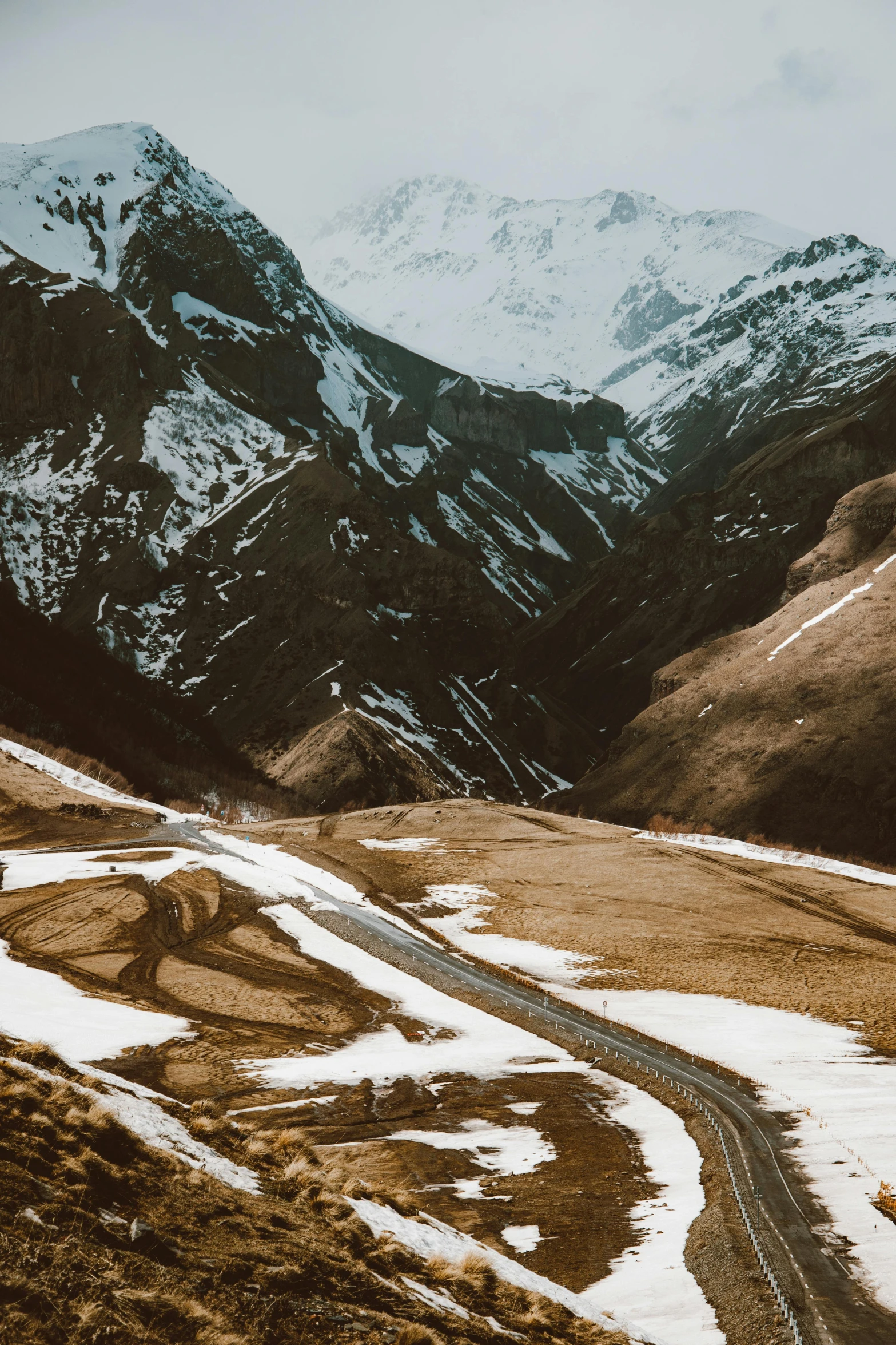 a man riding a motorcycle down a snow covered road, pexels contest winner, les nabis, the middle of a valley, lush valley, 4 k cinematic panoramic view, alp