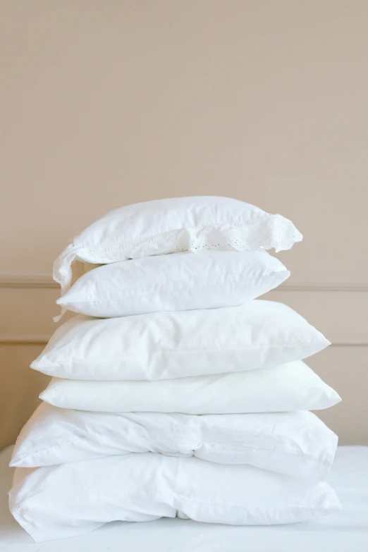 a stack of pillows sitting on top of a bed, white: 0.5, cracks, overview, traditional medium