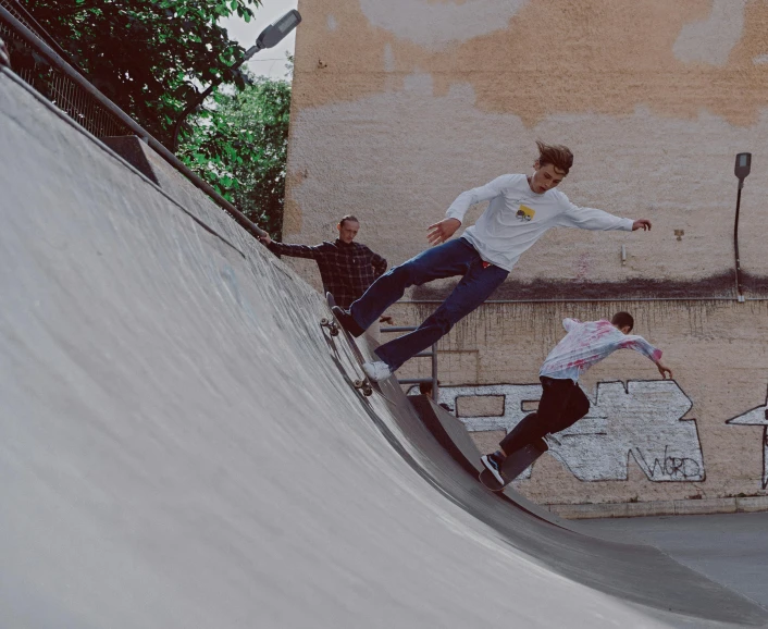 a man riding a skateboard up the side of a ramp, a picture, by Emma Andijewska, pexels contest winner, very detailed curve, everyone having fun, boys, faded worn