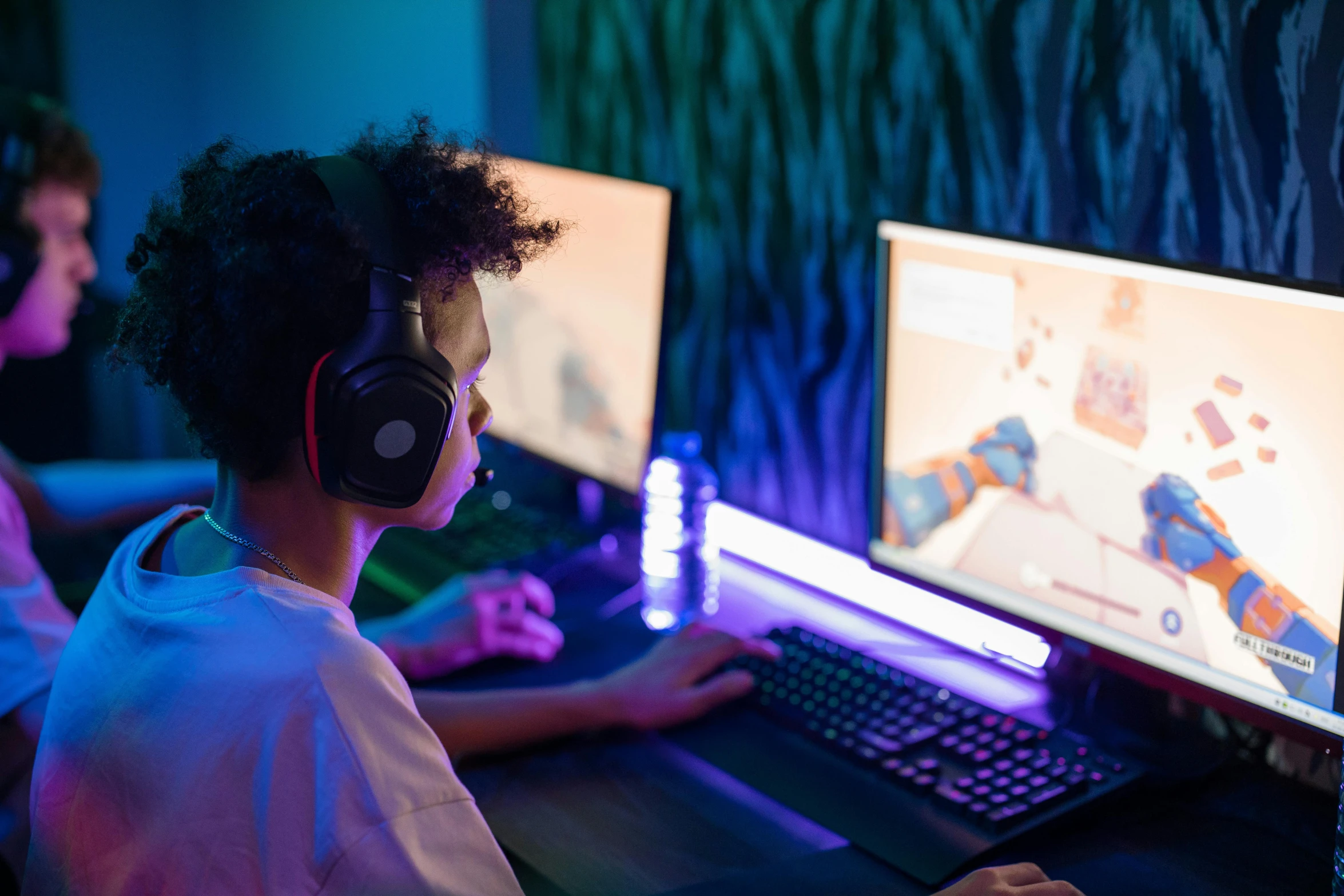 a couple of people that are sitting in front of a computer, video game, wearing purple headphones, colour corrected, teenage boy