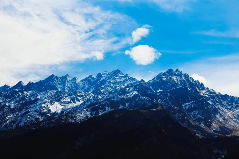 the mountains are covered in snow under a blue sky, an album cover, trending on unsplash, uttarakhand, thumbnail, 4 k hd wallpapear, dark-skinned