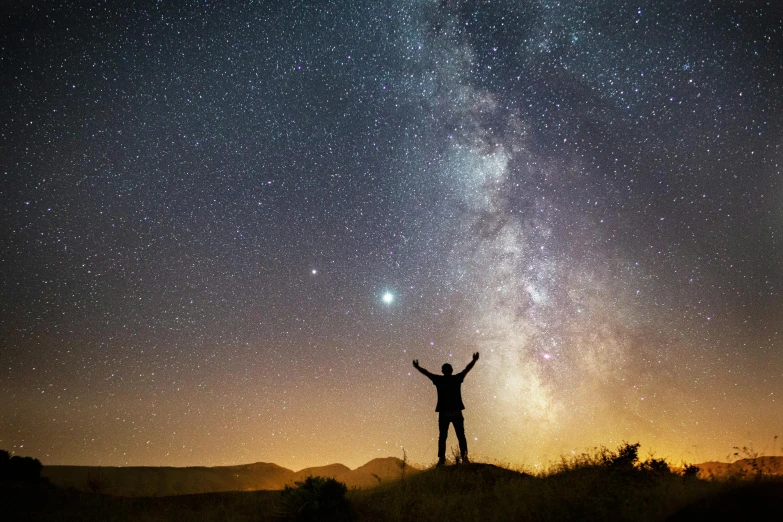 a person standing on top of a hill under a sky full of stars, pexels contest winner, triumphant pose, stars and planets visible, the milk way up above, instagram post