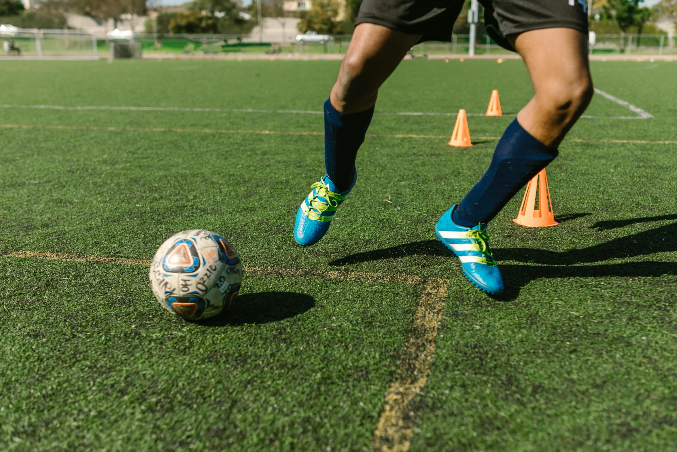 a person kicking a soccer ball on a field, educational, bay area, cups and balls, instagram photo