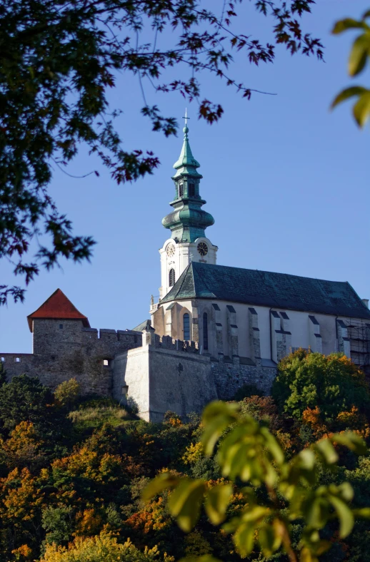 a large building sitting on top of a lush green hillside, inspired by Károly Markó the Elder, baroque, lead - covered spire, during autumn, citadel, exterior view