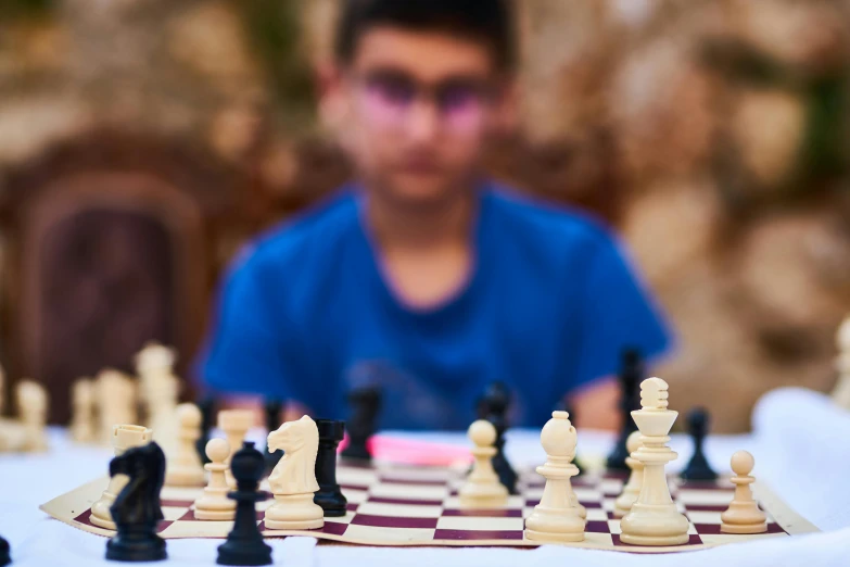 a young man playing a game of chess, by Joe Bowler, pexels contest winner, avatar image, jordan, zoomed in shots, eytan zana