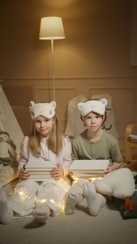 a couple of kids sitting on top of a bed, wearing barn owl mask, soft warm lighting, official product photo, crown on head