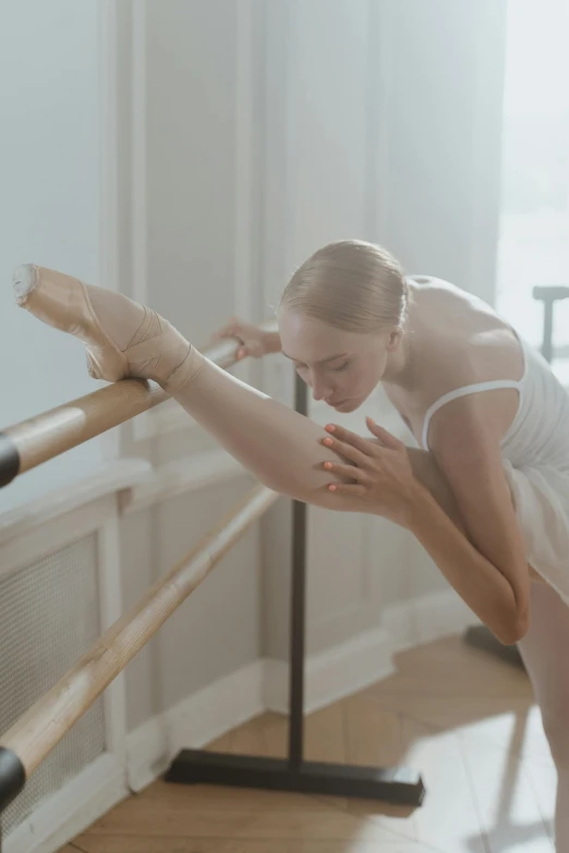 a woman in a white dress doing a ballet pose, pexels contest winner, holding a wooden staff, working out, contemplating, square