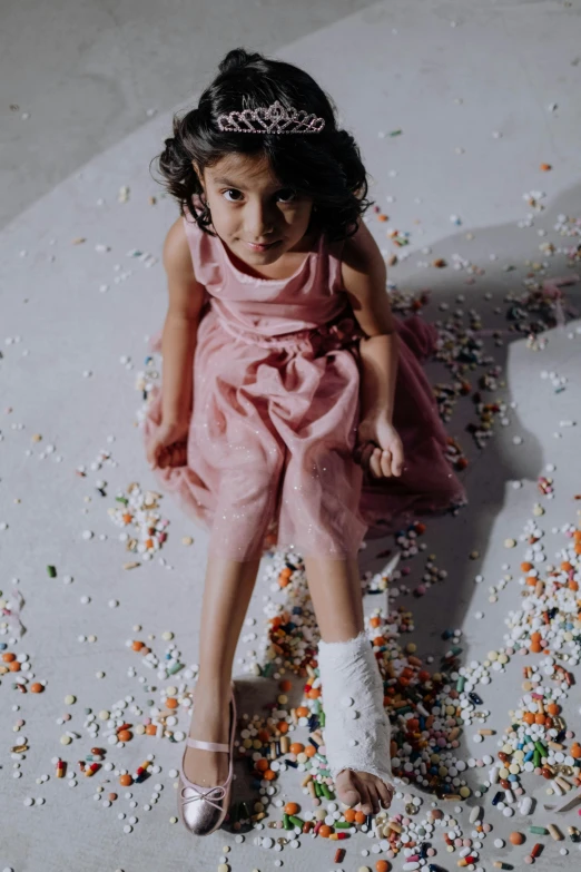 a little girl sitting on a floor covered in sprinkles, by irakli nadar, pexels contest winner, gutai group, award winning movie still, ameera al-taweel, detail shot, wearing dress