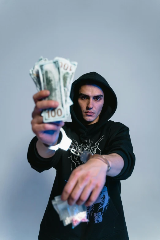 a man in a hoodie holding a bunch of money, an album cover, pexels contest winner, threatening pose, hasan piker, discord profile picture, asher duran