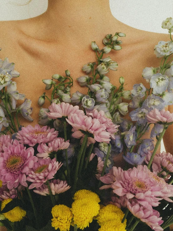 a woman is holding a bouquet of flowers, inspired by Elsa Bleda, neck zoomed in, joel meyerowitz, chrysanthemum and hyacinth, grimes - book 1 album cover